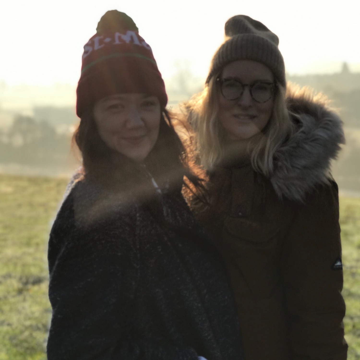 a photo of catryn ramasut and hannah berryman shooting Rockfield outside in a field.