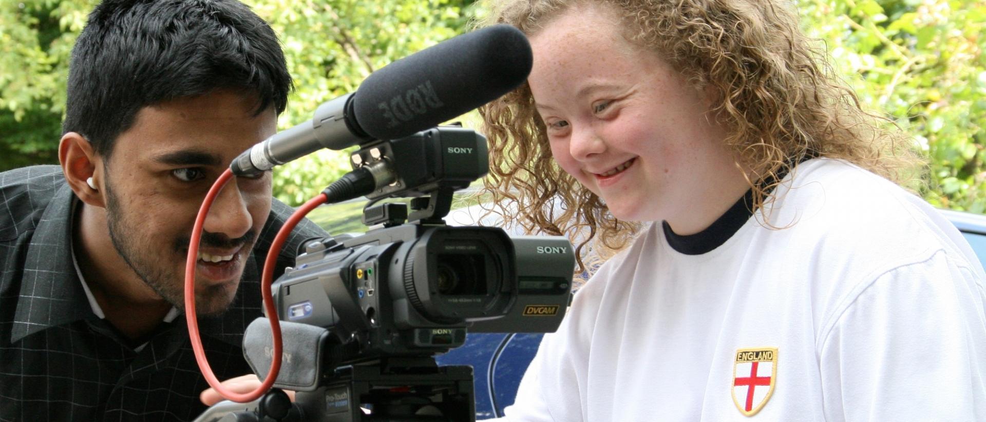 a person teaching another person how to make their own films with a camera