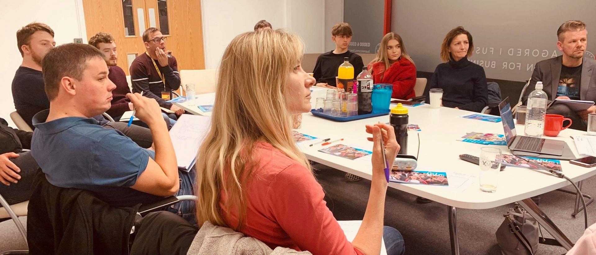 people sitting around a table learning about the film industry at a 73 connect event