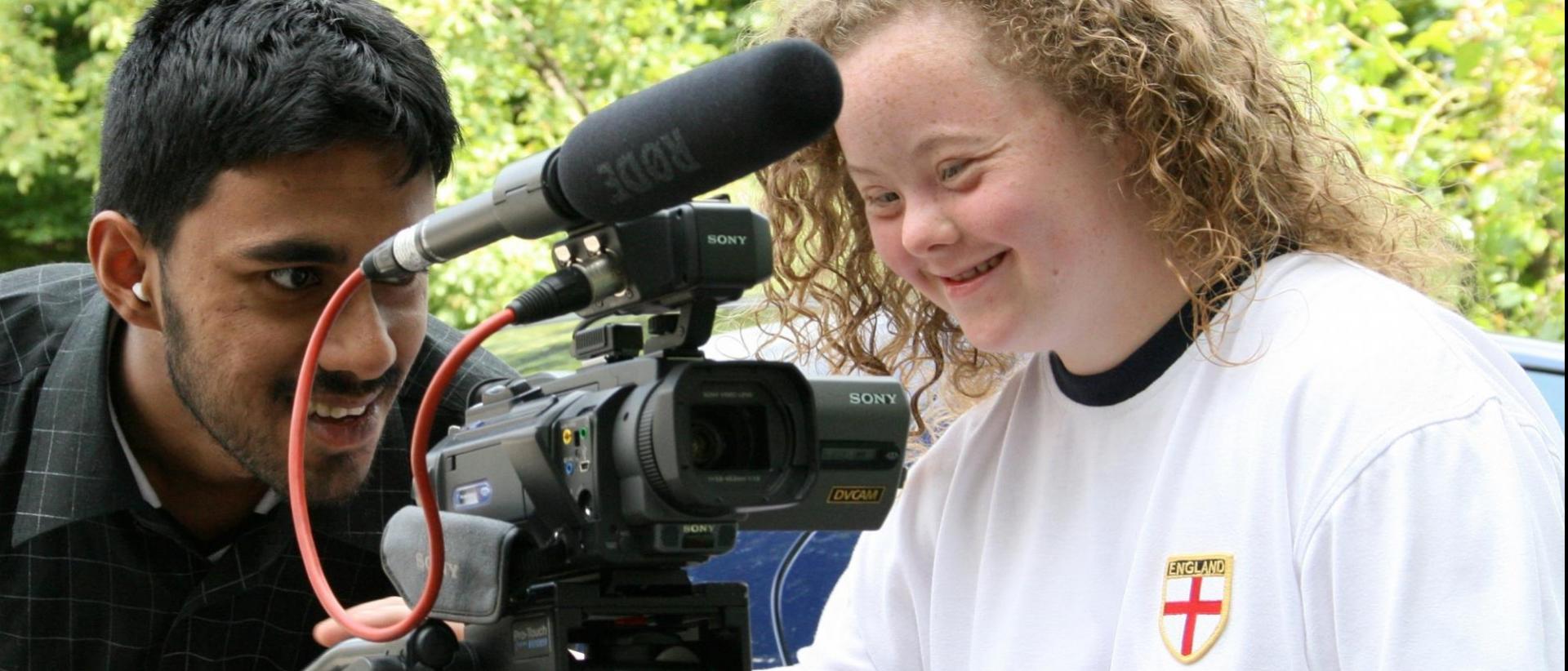 two people outside shooting a film with a camera