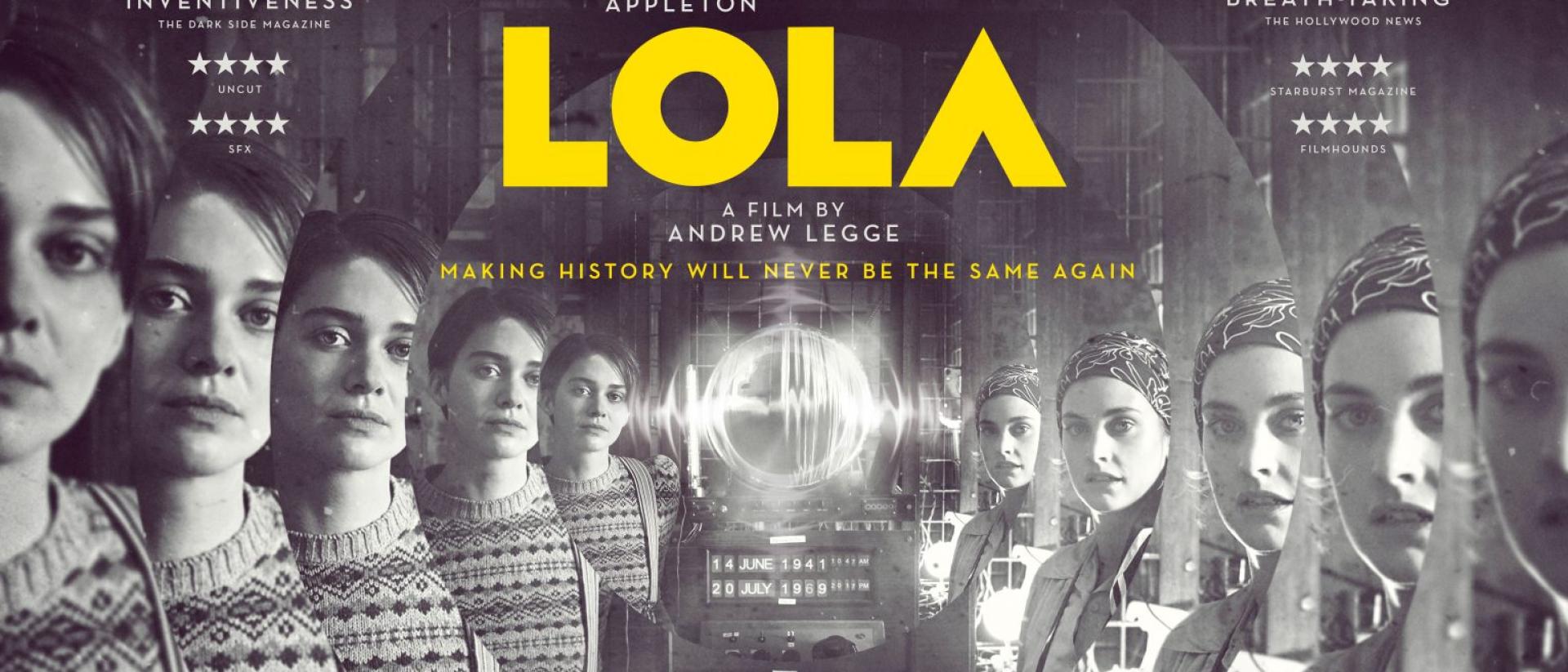 black and white still from lola featuring two people in 1940s costume standing in front of an old machine with a screen showing the moon landing