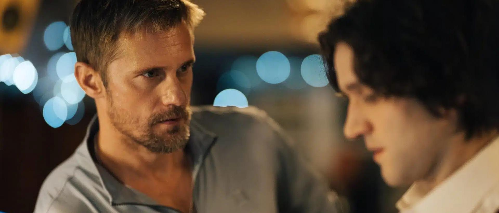 still from pillion featuring two men standing at a bar