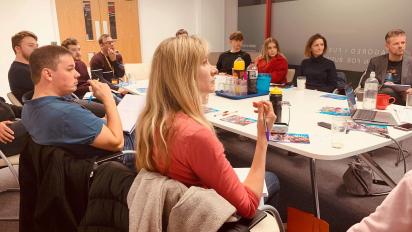 people sitting around a table learning about the film industry at a 73 connect event