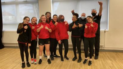 a group of young people in school uniform pose for a photo with their thumbs up