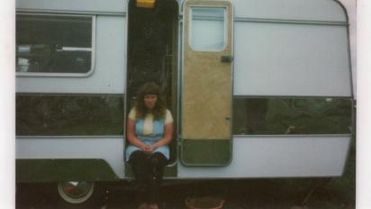 old polaroid photo from the 1970s of a woman sitting in a caravan's open doorway