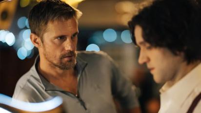 still from pillion featuring two men standing at a bar